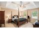 Spacious main bedroom featuring a four-poster bed, tray ceiling, and neutral walls at 325 N Oakland Cir, Mcdonough, GA 30253