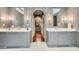Expansive bathroom with dual vanities, marble countertops, and an arched doorway leading to a walk-in closet at 2440 Peachtree Nw Rd # 9, Atlanta, GA 30305