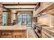 Elegant kitchen featuring brick walls, marble countertops, stainless steel appliances, and exposed wooden beams at 2440 Peachtree Nw Rd # 9, Atlanta, GA 30305
