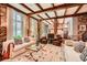 Open-concept living room with exposed brick, wood ceiling beams, and large windows at 2440 Peachtree Nw Rd # 9, Atlanta, GA 30305