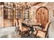 Rustic wine cellar with brick walls, a wooden door, and a tasting table under a chandelier at 2440 Peachtree Nw Rd # 9, Atlanta, GA 30305