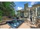 Landscaped backyard with large hot tub and upper deck with grill, creating an outdoor oasis for entertaining at 3004 High Vista Walk, Woodstock, GA 30189