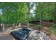 Backyard deck with hot tub with wooden seating and bench overlooking a peaceful wooded area at 3004 High Vista Walk, Woodstock, GA 30189