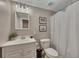 Neutral toned bathroom features a vanity, a toilet, framed art, and a shower/tub with shower curtain at 3004 High Vista Walk, Woodstock, GA 30189