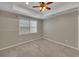 An empty bedroom features neutral tones, carpet, a ceiling fan, and a window with blinds at 3004 High Vista Walk, Woodstock, GA 30189