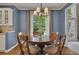 Traditional dining room with hardwood floors, round table, chandelier and natural light from the window at 3004 High Vista Walk, Woodstock, GA 30189