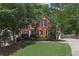 Attractive brick home featuring black shutters, a well-manicured lawn, and mature trees at 3004 High Vista Walk, Woodstock, GA 30189