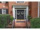 Inviting brick home entrance featuring a black double door with wreaths and manicured landscaping at 3004 High Vista Walk, Woodstock, GA 30189