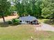 A high-angle view showcases this delightful home with a spacious yard and verdant surroundings at 7619 Campground Rd, Cumming, GA 30040