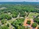 Bird's-eye view of a 1.2-acre parcel featuring a charming home nestled amidst a lush tree canopy at 7619 Campground Rd, Cumming, GA 30040