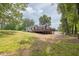 Backyard view of home featuring a wooden deck, spacious lawn, and mature trees at 7619 Campground Rd, Cumming, GA 30040