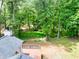View of backyard and deck surrounded by mature trees; a peaceful outdoor space at 7619 Campground Rd, Cumming, GA 30040