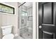 Bathroom with tiled shower, glass door, window and black door at 7619 Campground Rd, Cumming, GA 30040