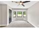 Bedroom featuring new carpet, ceiling fan, white trim, and bay windows at 7619 Campground Rd, Cumming, GA 30040