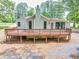 Exterior of home showing the expansive deck, light-green siding, and black-framed windows at 7619 Campground Rd, Cumming, GA 30040