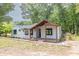 Charming single-story home with a covered front porch, set amongst mature trees and landscaped yard at 7619 Campground Rd, Cumming, GA 30040