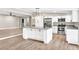 Open kitchen with stainless appliances, center island, granite countertops, and pendant lighting, flowing into the living area at 7619 Campground Rd, Cumming, GA 30040