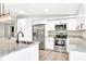 Modern kitchen with white cabinets, stainless steel appliances, granite countertops, and an island with stylish pendant lights at 7619 Campground Rd, Cumming, GA 30040