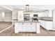 Bright kitchen featuring white cabinets, stainless steel appliances, a center island, and granite countertops at 7619 Campground Rd, Cumming, GA 30040