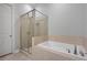 Bright bathroom featuring a glass shower stall and a soaking tub with tile surround at 891 Proctor Oaks Nw St, Atlanta, GA 30318