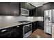 Kitchen with stainless steel appliances, granite countertops, white backsplash and dark cabinets at 891 Proctor Oaks Nw St, Atlanta, GA 30318