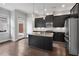 Kitchen with center island, stainless steel appliances and dark cabinetry open to living space at 891 Proctor Oaks Nw St, Atlanta, GA 30318