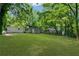 Large, green backyard with a view of the house, mature trees, and green grass at 2385 Perkerson Sw Rd, Atlanta, GA 30315