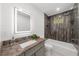 Modern bathroom with a walk-in shower, granite countertop, and a large, lighted mirror at 2385 Perkerson Sw Rd, Atlanta, GA 30315