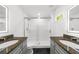 Modern bathroom featuring dual sinks with granite countertops, a glass shower, and lighted mirrors at 2385 Perkerson Sw Rd, Atlanta, GA 30315