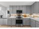 Bright kitchen with stainless appliances, grey cabinets, and light countertops at 2385 Perkerson Sw Rd, Atlanta, GA 30315