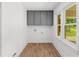 Bright laundry room features gray cabinets, hardwood floors, and natural light from a large window at 2385 Perkerson Sw Rd, Atlanta, GA 30315