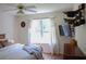 Bright bedroom with a ceiling fan, TV, and a large window offering a view of the greenery at 287 Diamond Ct, Carrollton, GA 30116