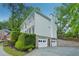 Side view of a two-story home with a three-car garage and well-maintained landscaping at 2987 Windward Nw Dr, Kennesaw, GA 30152