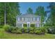 Charming brick home featuring a manicured front lawn, mature trees, and classic architectural details at 2987 Windward Nw Dr, Kennesaw, GA 30152