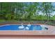 Inviting in-ground pool with expansive wooden deck, swan floats, and lush, mature trees at 2987 Windward Nw Dr, Kennesaw, GA 30152