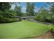 Landscaped front yard with green grass and mature trees leading up to a single story home at 3353 Greenfield Dr, Marietta, GA 30068