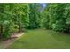 Expansive backyard area features lush lawn and mature trees, creating a private outdoor oasis at 140 Emily Sw Dr, Lilburn, GA 30047