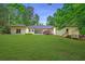 Large, well-maintained backyard offers ample space for activities, complemented by mature trees and a cozy patio at 140 Emily Sw Dr, Lilburn, GA 30047