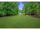 Spacious backyard with lush lawn and mature trees, offering a blank canvas for your outdoor dreams at 140 Emily Sw Dr, Lilburn, GA 30047