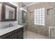 Luxurious bathroom with a marble vanity, glass shower, and decorative glass-block window at 140 Emily Sw Dr, Lilburn, GA 30047