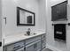 Stylish powder room with a gray vanity, quartz countertop, black fixtures, and a sleek modern mirror at 140 Emily Sw Dr, Lilburn, GA 30047