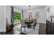 Dining room with dark wood table, beige chairs, a large window, and stylish decorations at 140 Emily Sw Dr, Lilburn, GA 30047