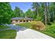Beautiful ranch-style home featuring mature trees, a well-maintained lawn, and a long driveway at 140 Emily Sw Dr, Lilburn, GA 30047