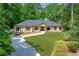 Charming ranch-style home with a manicured lawn, mature trees, and a welcoming walkway to the front door at 140 Emily Sw Dr, Lilburn, GA 30047