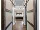 Hallway view of a bedroom showcasing barn doors, hardwood floors, and a ceiling fan at 140 Emily Sw Dr, Lilburn, GA 30047