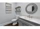 Powder room featuring round mirror, floating shelves, and a gray vanity with a white countertop at 140 Emily Sw Dr, Lilburn, GA 30047
