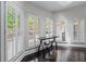 Bright sitting area with dark hardwood floors, plantation shutters, and tall bistro table with seating at 140 Emily Sw Dr, Lilburn, GA 30047