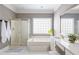 Bright bathroom with a glass block window over the tub and a separate glass enclosed shower with gold trim at 1887 Chamdun Pl, Brookhaven, GA 30341