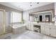 Bathroom featuring a double vanity, glass block window over tub, and a separate glass enclosed shower with gold trim at 1887 Chamdun Pl, Brookhaven, GA 30341
