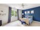 Charming bedroom with blue accent wall, carpet flooring, and a cozy bed with nautical themed decor at 1887 Chamdun Pl, Brookhaven, GA 30341